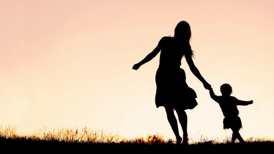 Silhouette of Mother and Baby Daughter Running and Dancing at Sunset