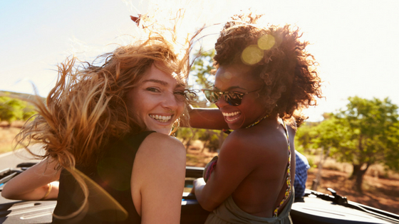 two women in a car with wind in their hair